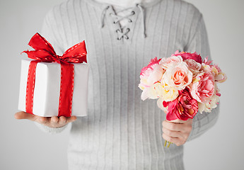 Image showing man holding bouquet of flowers and gift box