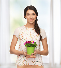 Image showing lovely housewife with flower in pot