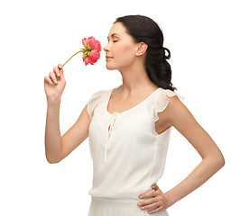 Image showing young and beautiful woman smelling flower