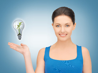 Image showing woman showing green light bulb