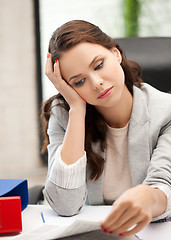 Image showing bored and tired woman behid the table