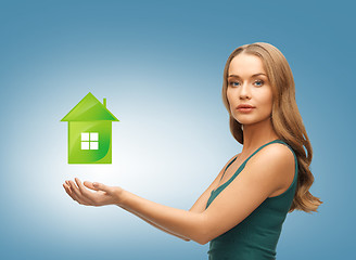 Image showing woman holding green house in her hands