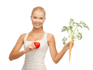 Image showing woman holding heart symbol and carrot
