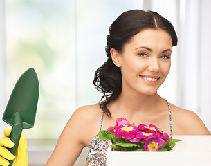 Image showing housewife with flower in box and gardening trowel