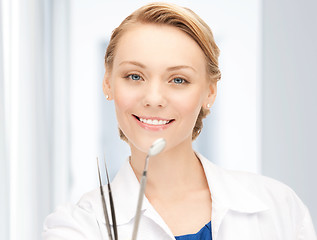 Image showing attractive female dentist with tools