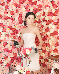 Image showing woman with bicycle and background full of roses