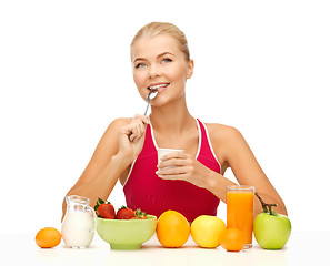 Image showing young woman eating healthy breakfast