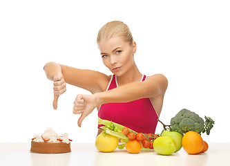 Image showing woman with fruits showing thumbs down to cake