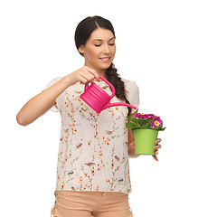 Image showing housewife with flower in pot and watering can