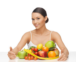 Image showing woman with measuring tape and lots of fruits