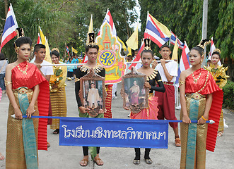 Image showing Thai youth in traditional clothing hold photographs of the King