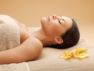 Image showing woman in spa salon lying on the massage desk