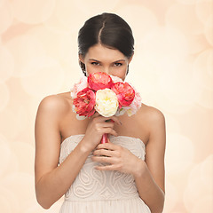 Image showing woman smelling bouquet of flowers