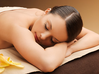 Image showing woman in spa salon lying on the massage desk