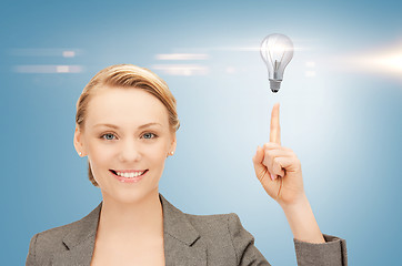 Image showing woman pointing her finger at light bulb