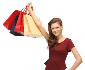 Image showing teenage girl in red dress with shopping bags