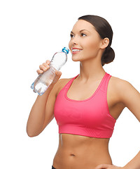 Image showing sporty woman drinking water from bottle