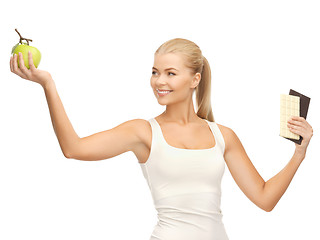 Image showing sporty woman with apple and chocolate bars