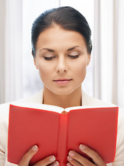 Image showing calm and serious woman with book