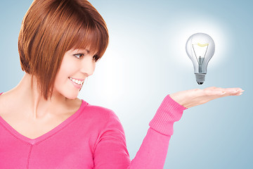 Image showing woman showing light bulb on the palm of her hand