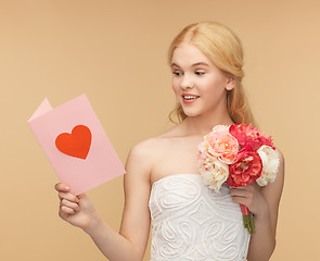 Image showing young woman holding flower and postcard