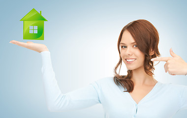 Image showing woman pointing her finger at green eco house