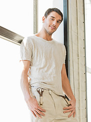 Image showing handsome man standing on the windowsill