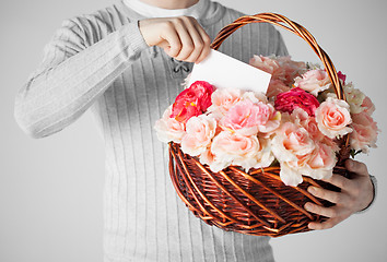 Image showing man holding basket full of flowers and postcard