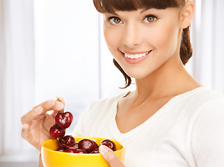 Image showing healthy woman holding bowl with cherries