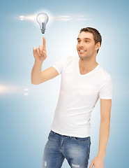 Image showing handsome man pointing at light bulb