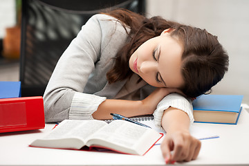 Image showing bored and tired woman sleeping on the table