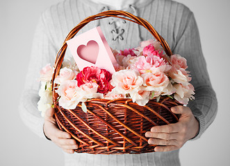 Image showing man holding basket full of flowers and postcard