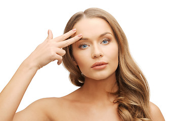 Image showing beautiful woman pointing to forehead