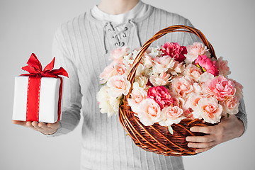 Image showing man holding basket full of flowers and gift box