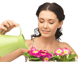 Image showing housewife with flower in pot and watering can