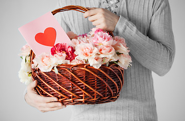 Image showing man holding basket full of flowers and postcard