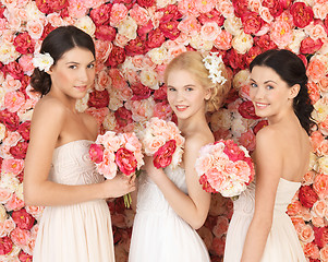 Image showing three women with background full of roses