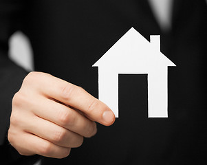 Image showing man in suit holding paper house