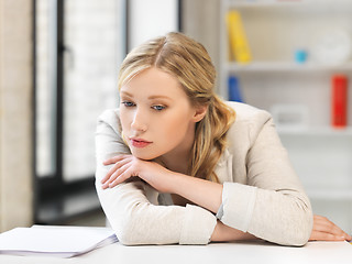 Image showing bored and tired woman behind the table