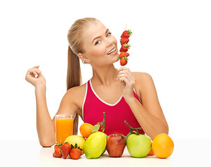 Image showing woman with organic food eating strawberry