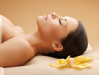 Image showing woman in spa salon lying on the massage desk