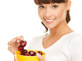 Image showing healthy woman holding bowl with cherries