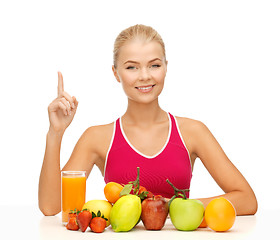 Image showing woman with juice and fruits holding finger up