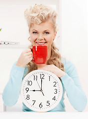 Image showing attractive businesswoman with clock and red cup