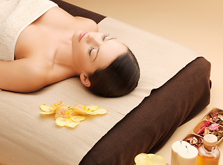 Image showing woman in spa salon lying on the massage desk