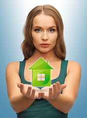 Image showing woman holding green house in her hands