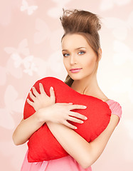 Image showing happy and smiling woman with heart-shaped pillow
