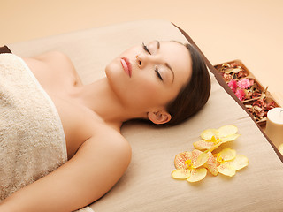 Image showing woman in spa salon lying on the massage desk