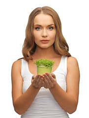 Image showing woman with green grass in pot