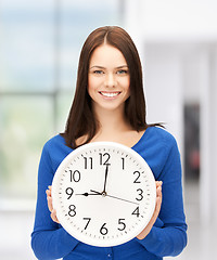 Image showing businesswoman with wall clock